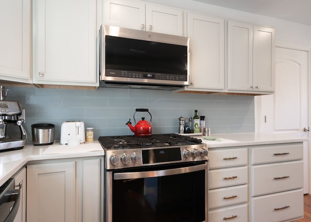 kitchen featuring light countertops, white cabinets, tasteful backsplash, and appliances with stainless steel finishes