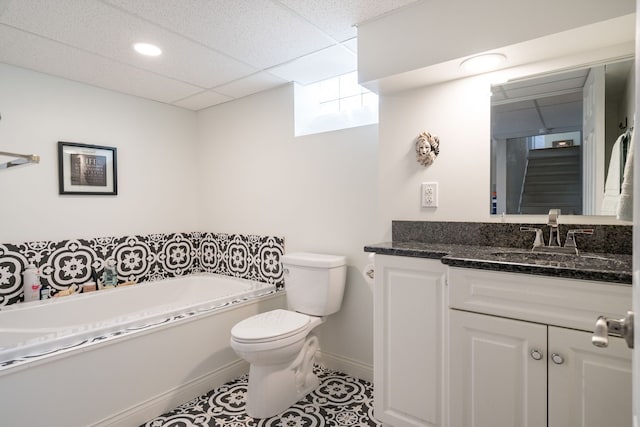 bathroom featuring vanity, a paneled ceiling, a garden tub, toilet, and tile patterned floors