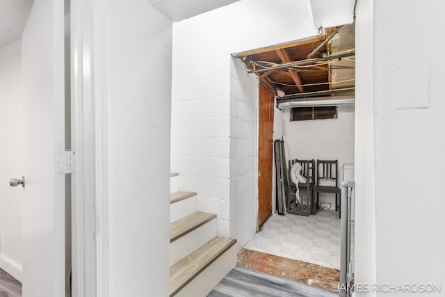 unfinished basement featuring tile patterned floors and concrete block wall