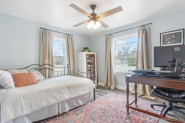 bedroom featuring light wood-style floors, baseboards, and ceiling fan