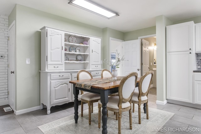 dining area featuring light tile patterned flooring and baseboards