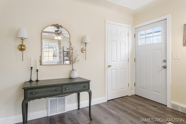 entryway featuring ceiling fan, wood finished floors, visible vents, and baseboards