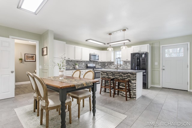 dining area featuring light tile patterned floors and baseboards