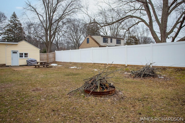 view of yard with an outdoor fire pit and fence