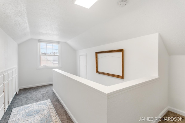 bonus room featuring lofted ceiling, baseboards, carpet floors, and a textured ceiling