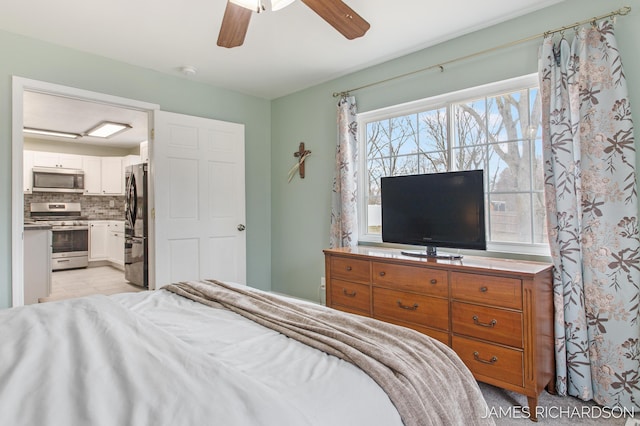 bedroom featuring ensuite bathroom, freestanding refrigerator, and ceiling fan