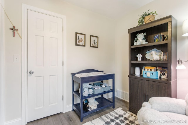 interior space with visible vents, baseboards, and wood finished floors