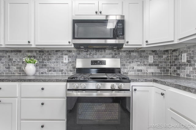 kitchen with decorative backsplash, appliances with stainless steel finishes, and white cabinets