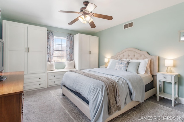 bedroom featuring visible vents, light carpet, and a ceiling fan