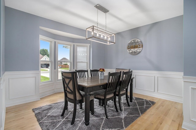 dining space featuring a wainscoted wall and wood finished floors