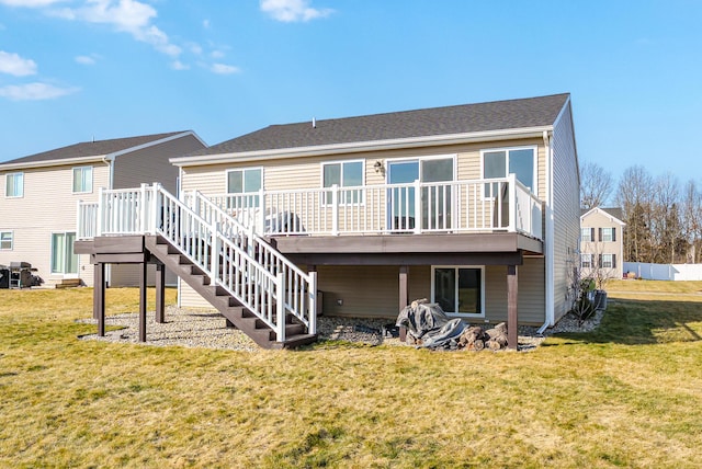 back of property featuring a lawn, a deck, and stairs