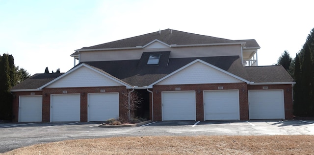 view of front of house featuring brick siding and a shingled roof