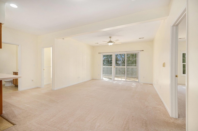 unfurnished room featuring light carpet, a ceiling fan, and baseboards