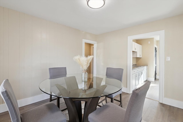 dining space featuring baseboards and wood finished floors