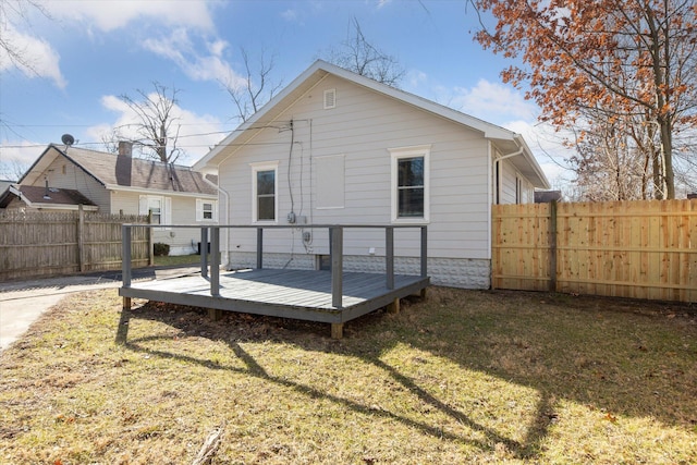 back of property featuring a yard, a deck, and a fenced backyard