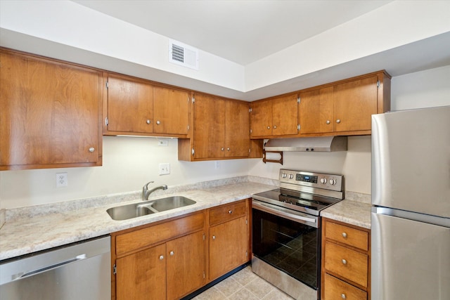 kitchen with visible vents, a sink, light countertops, appliances with stainless steel finishes, and exhaust hood