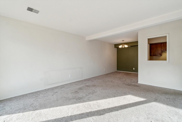 unfurnished room featuring visible vents, carpet floors, a notable chandelier, and beamed ceiling