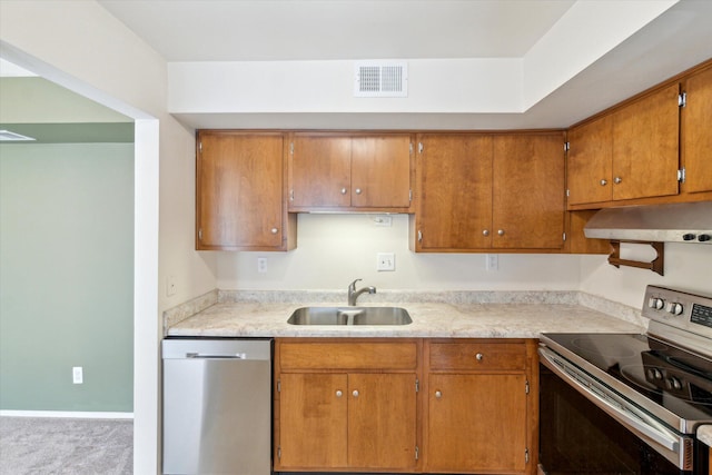 kitchen with visible vents, under cabinet range hood, light countertops, stainless steel appliances, and a sink