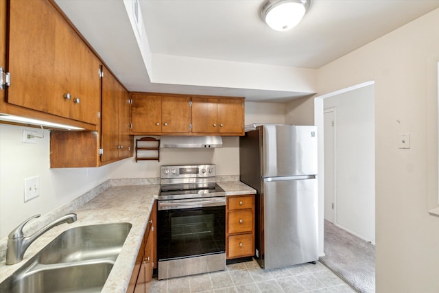 kitchen featuring extractor fan, light countertops, brown cabinets, appliances with stainless steel finishes, and a sink