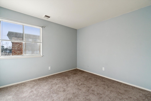 spare room featuring visible vents, carpet floors, and baseboards