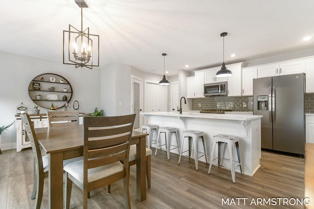 dining space featuring recessed lighting, light wood-style flooring, and baseboards