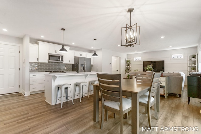 dining space with recessed lighting and light wood-type flooring