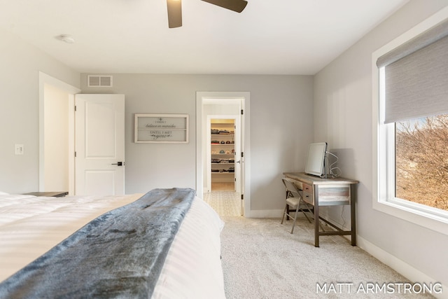 bedroom featuring visible vents, baseboards, carpet, and a walk in closet