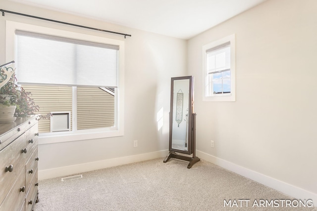 interior space featuring visible vents, baseboards, and carpet