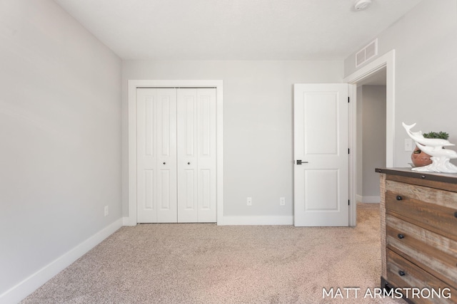 carpeted bedroom with a closet, visible vents, and baseboards