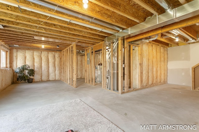 basement featuring water heater and electric panel