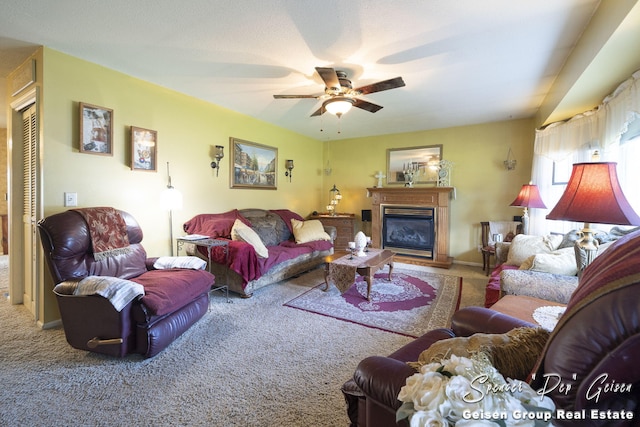 carpeted living room featuring a glass covered fireplace, a ceiling fan, and baseboards