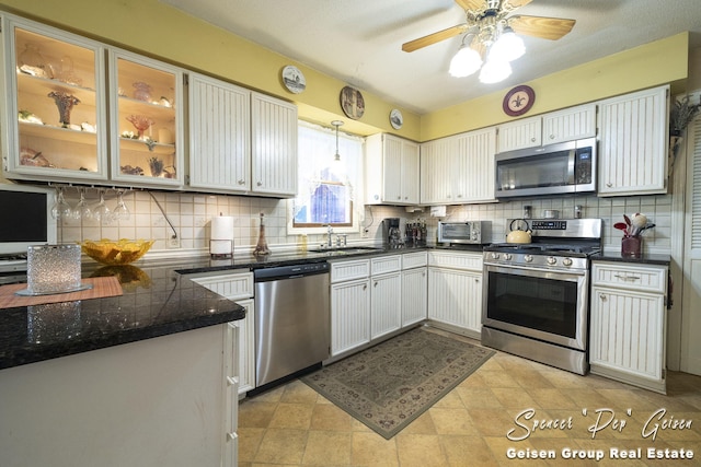 kitchen with dark countertops, tasteful backsplash, appliances with stainless steel finishes, and a sink