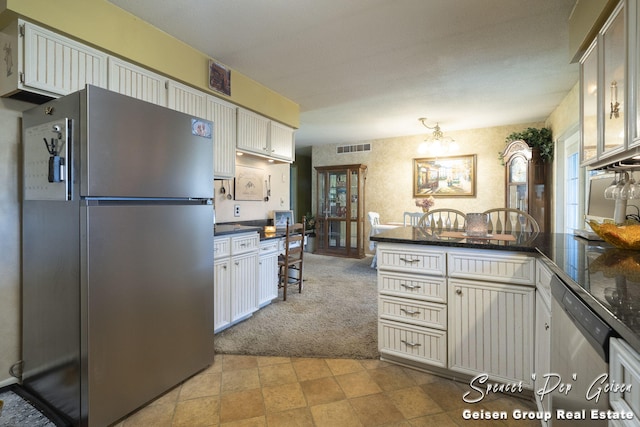 kitchen featuring visible vents, a peninsula, appliances with stainless steel finishes, light carpet, and dark countertops