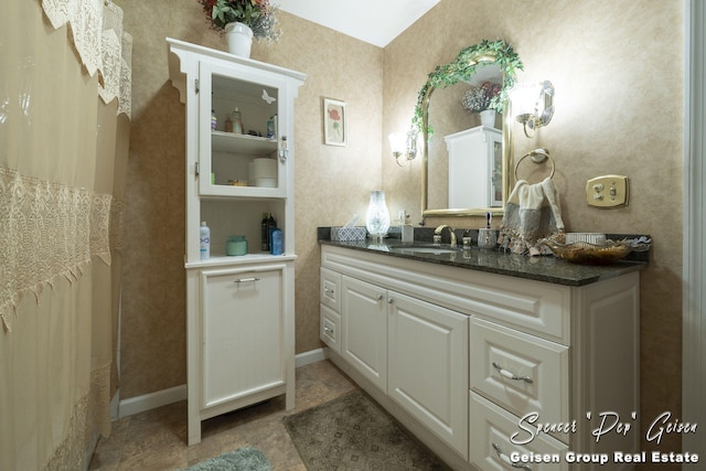 full bathroom featuring baseboards and vanity