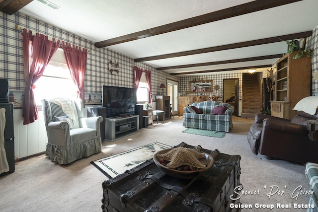 carpeted living area featuring beam ceiling, visible vents, a textured ceiling, and wallpapered walls