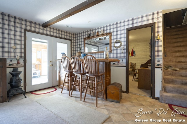 bar with wallpapered walls, beamed ceiling, stairway, french doors, and a bar