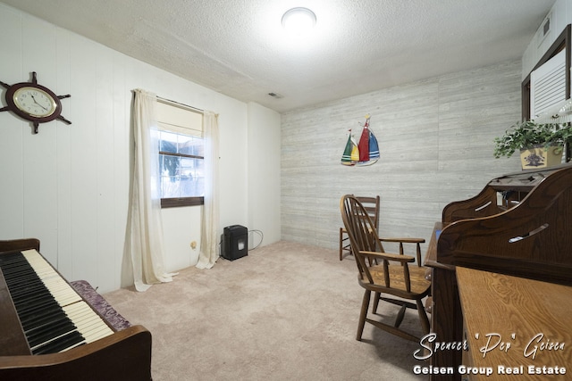 office space with carpet flooring, visible vents, and a textured ceiling