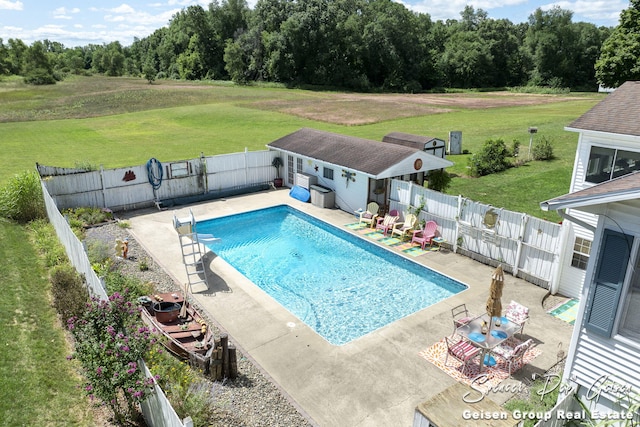 view of pool with a yard, an outbuilding, and a fenced backyard