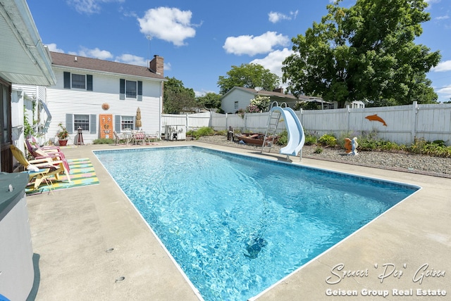 view of pool with a fenced backyard, a fenced in pool, a water slide, and a patio