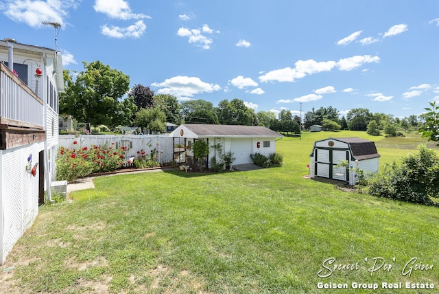 view of yard featuring a garden, an outbuilding, and fence