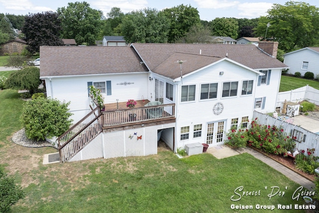 back of property with fence, a yard, roof with shingles, a wooden deck, and a chimney