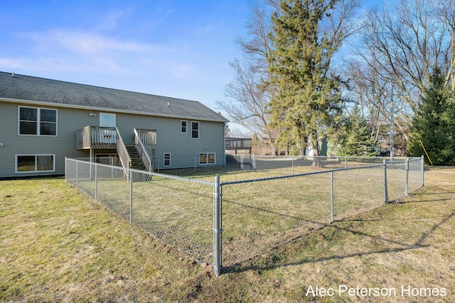 rear view of property featuring stairs, a deck, a lawn, and a fenced backyard