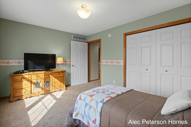 carpeted bedroom featuring a closet, visible vents, and baseboards