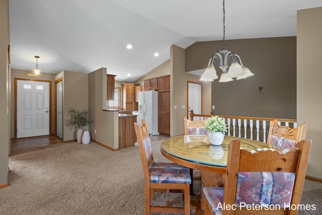 dining area featuring baseboards, lofted ceiling, light colored carpet, and a chandelier