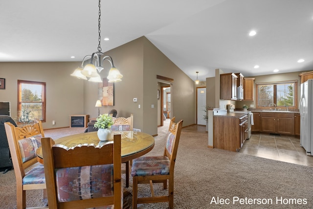 dining area with recessed lighting, light carpet, an inviting chandelier, and vaulted ceiling