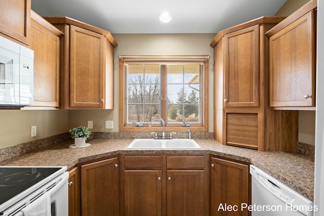 kitchen featuring brown cabinetry, white appliances, and a sink