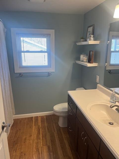 full bath featuring vanity, toilet, wood finished floors, and baseboards