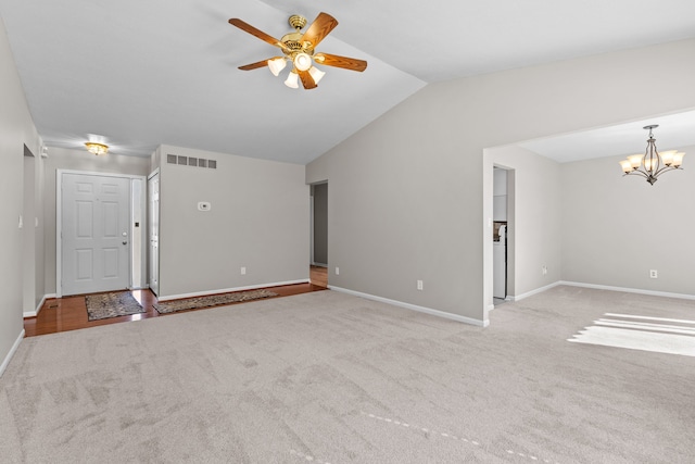 unfurnished living room featuring visible vents, carpet floors, vaulted ceiling, and ceiling fan with notable chandelier