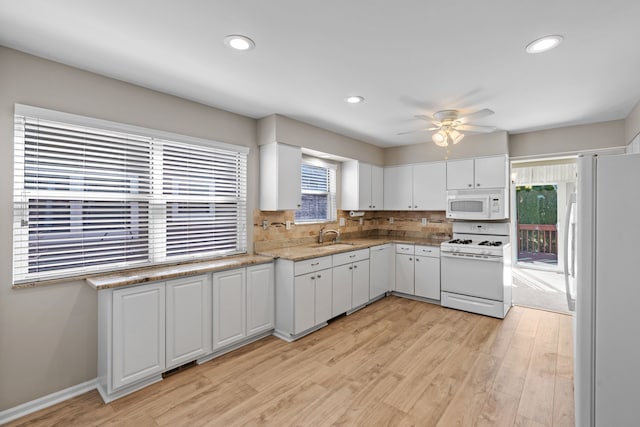 kitchen with ceiling fan, light wood-type flooring, white cabinets, white appliances, and a sink