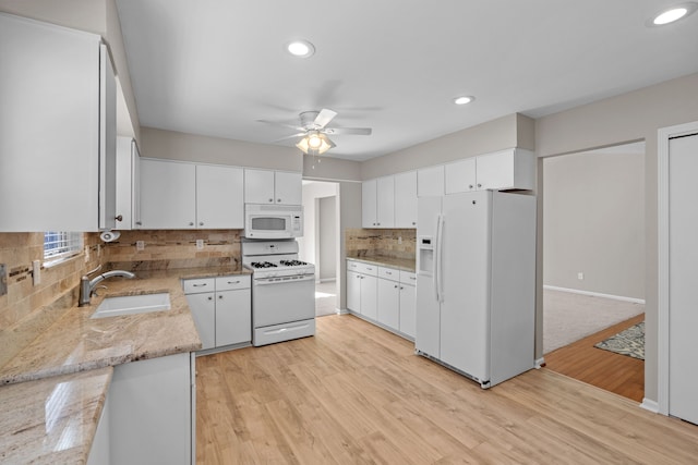 kitchen featuring ceiling fan, white appliances, light wood finished floors, and a sink